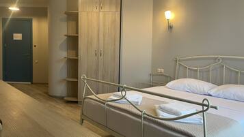 Un dormitorio con cama, armario y mesita de noche.
