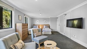 Een moderne hotelkamer met een groot bed, een bank, een klein tafeltje en een televisie.