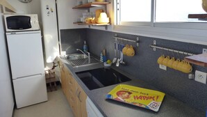 A compact kitchen with a microwave, sink, and shelves for dishes. - ATLANTES residence. Flat for 4 persons with ocean view (SOORTS HOSSEGOR)