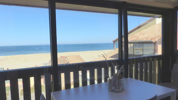 Een balkon met uitzicht op het strand en de oceaan.