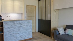 Een moderne keuken met een achterwand van steen, houten kastjes en een inbouweiland.