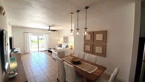A spacious kitchen with a dining area, a ceiling fan, and a view to the outside.