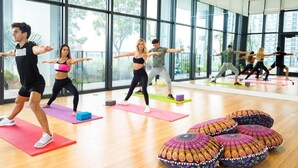 A group of people exercising in a spacious room with large windows and wooden floors. - Gorgeous modern apartment in the heart of Miami (Miami)