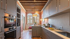 Una cocina moderna con electrodomésticos integrados, una isla central y techo de madera.
