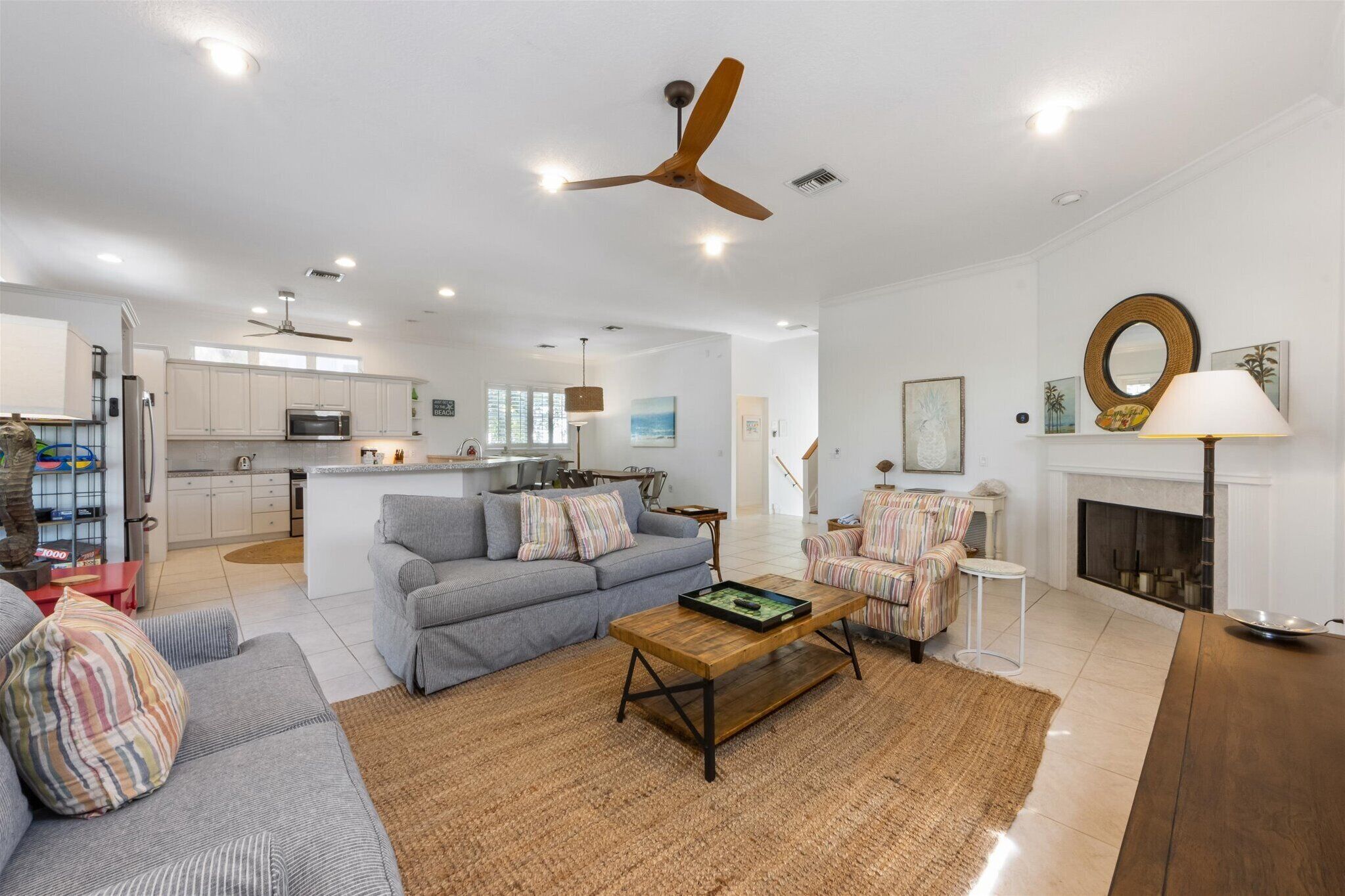 A spacious living area with a sofa, armchairs, a coffee table, and a fireplace.