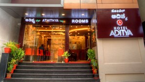 A modern hotel entrance with a staircase leading to the lobby, featuring a sign for 'ATHITHYA VSP ROOMS'. - Hotel Aditya Mysore (Mysore)