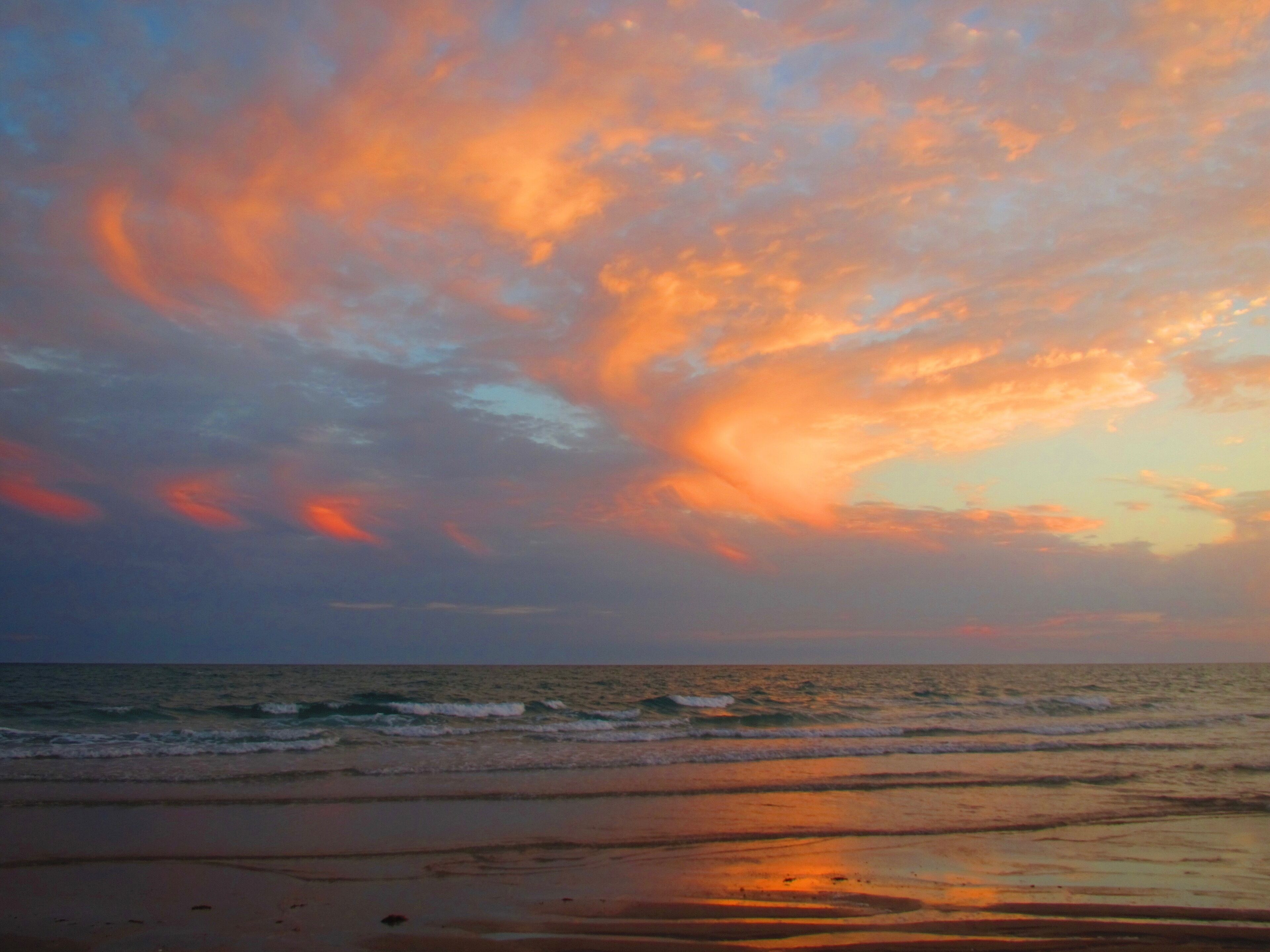 A beach with a sunset sky.