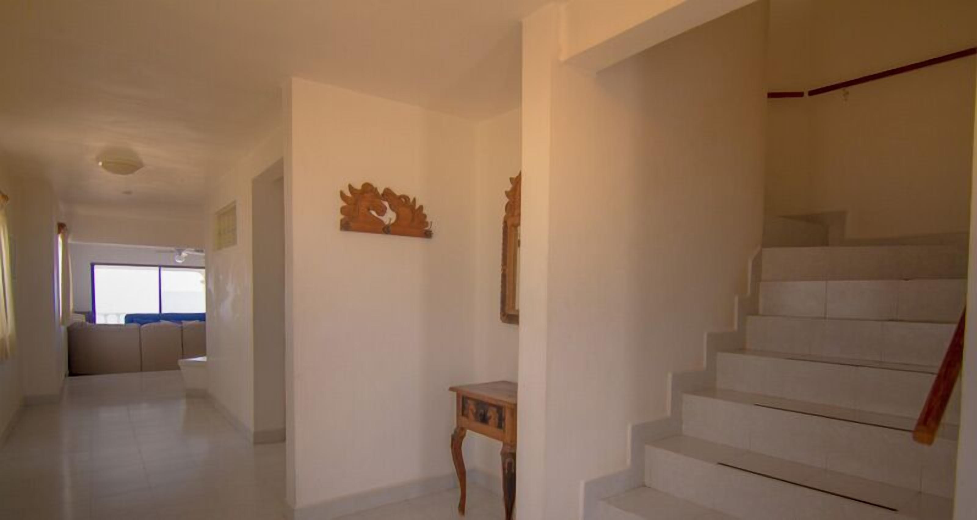 A spacious hallway with a staircase leading to an upper floor.