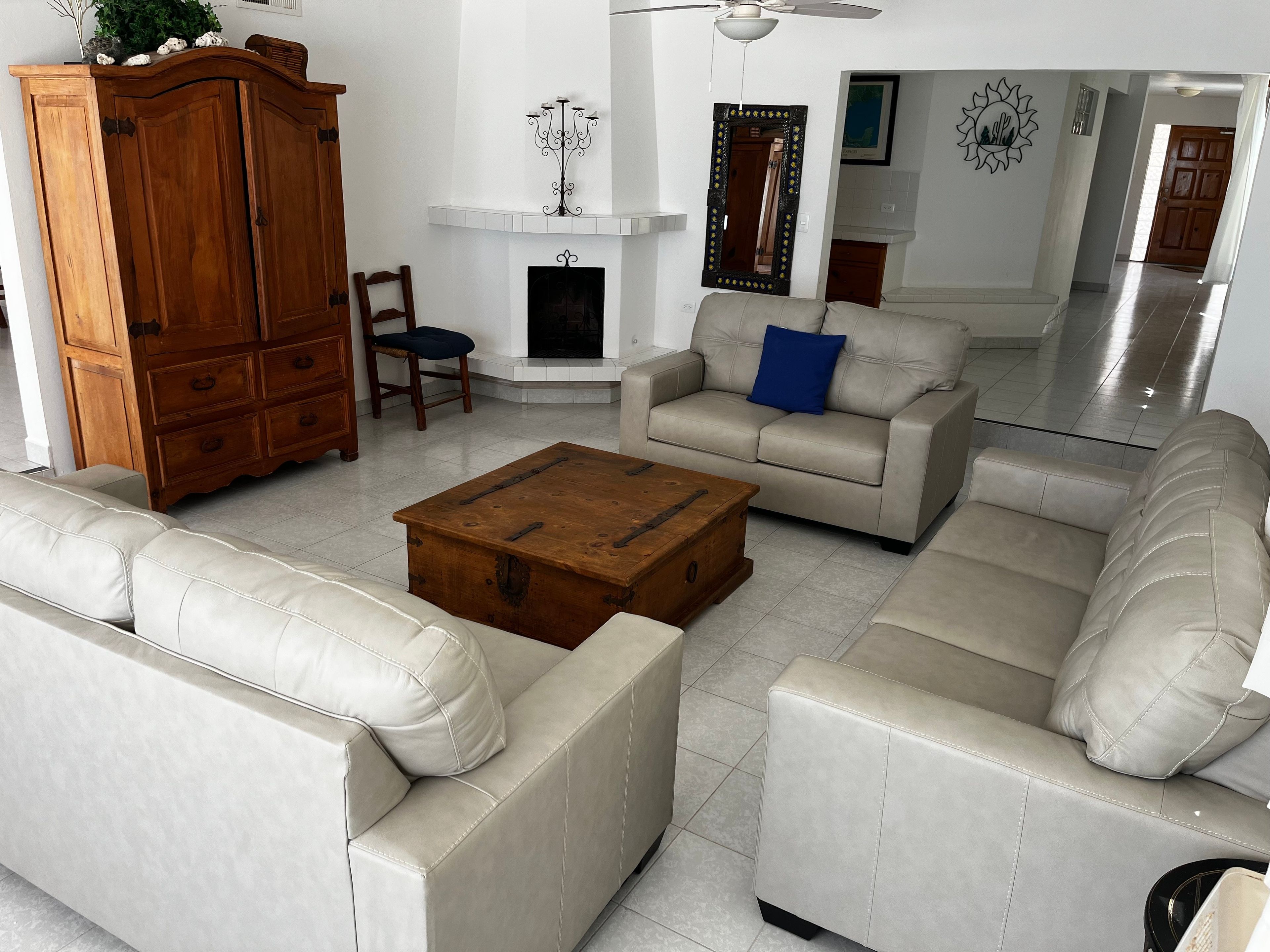A living room with a sofa, a wooden coffee table, a cabinet, and a fireplace.