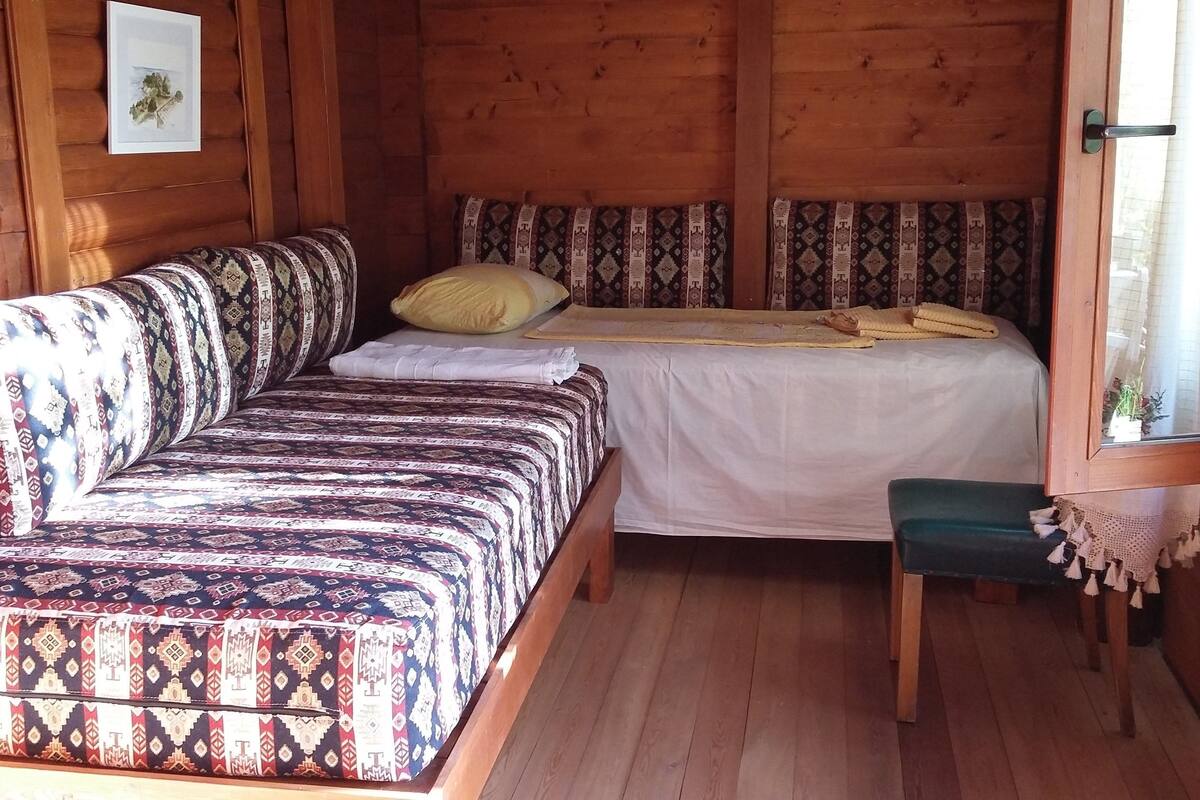 Una habitación acogedora de estilo cabaña, con una cama, un sofá y una pequeña mesa.