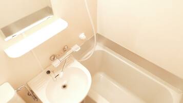 A bathroom with a white sink, a mirror above it, and a bathtub.