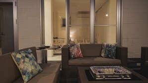 A modern living room with a sofa, a coffee table, and a small side table. - Niraikanai (Nanjo)