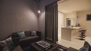 A modern outdoor living area with a sofa, cushions, and a coffee table. - Niraikanai (Nanjo)