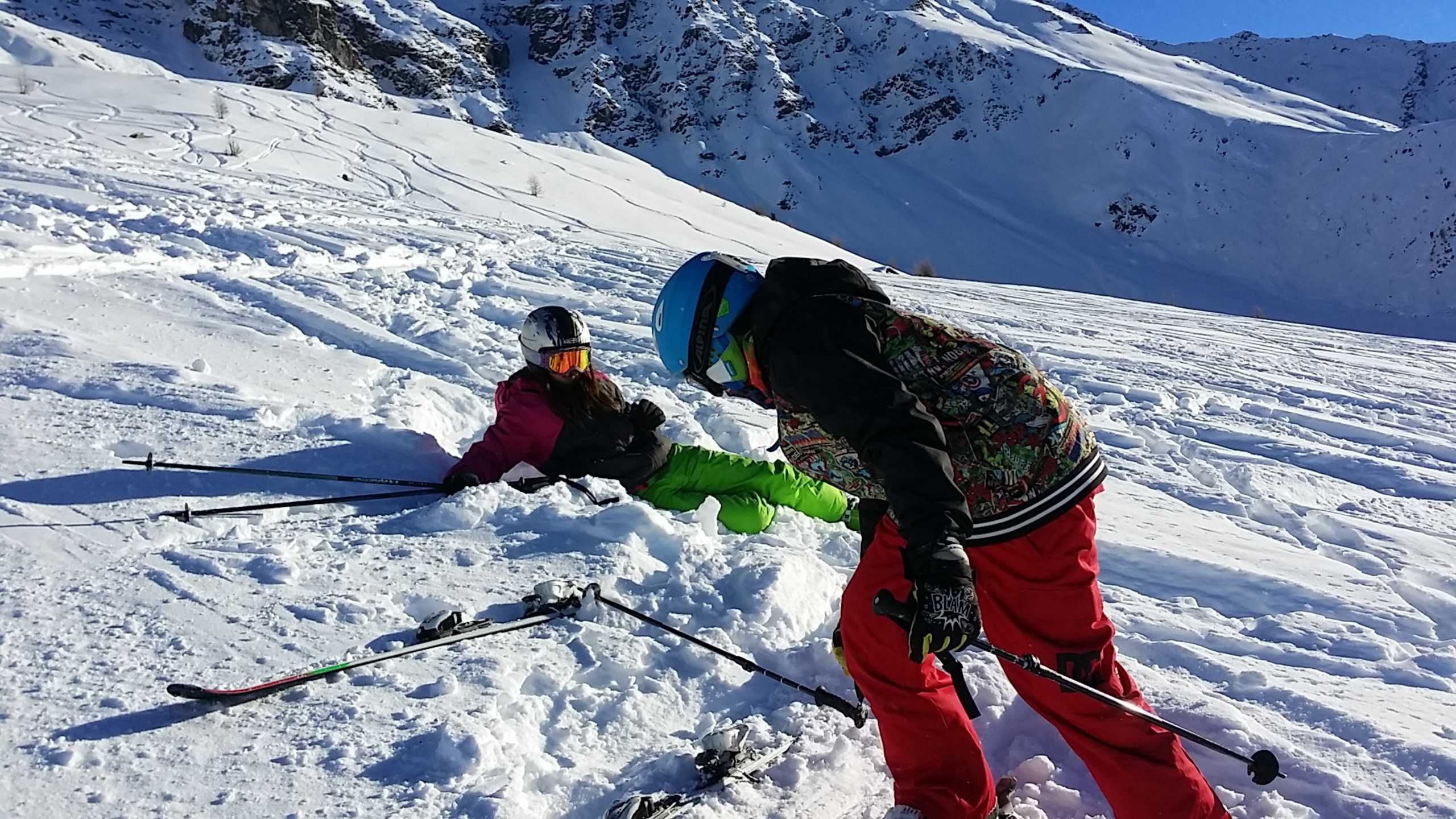 A snowy mountain slope with skiers.