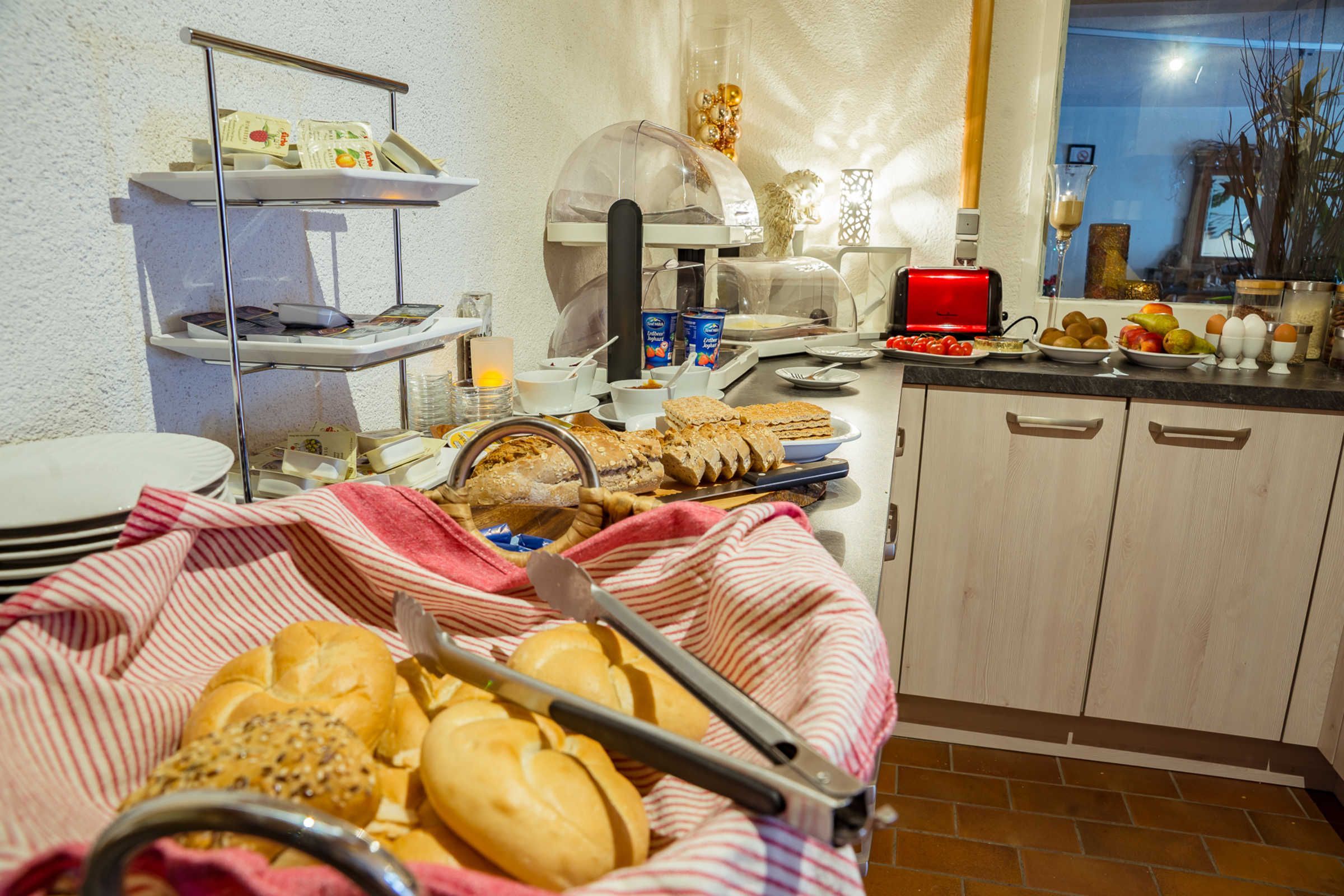 Un buffet de petit-déjeuner comprenant du pain, des viennoiseries et un grille-pain.