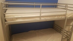 A bunk bed with metal railings and a blue wall in the background. - ---- Villa Lez ---- (Prades-le-Lez)