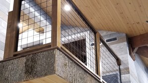 A wooden interior with a balcony and a ceiling with recessed lighting. - Storybook Caretaker's Cabin in the Woods -Clemson (Central)