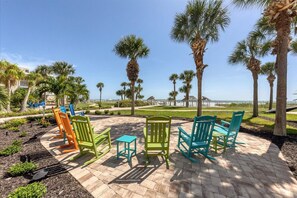 A patio area with outdoor seating and palm trees.