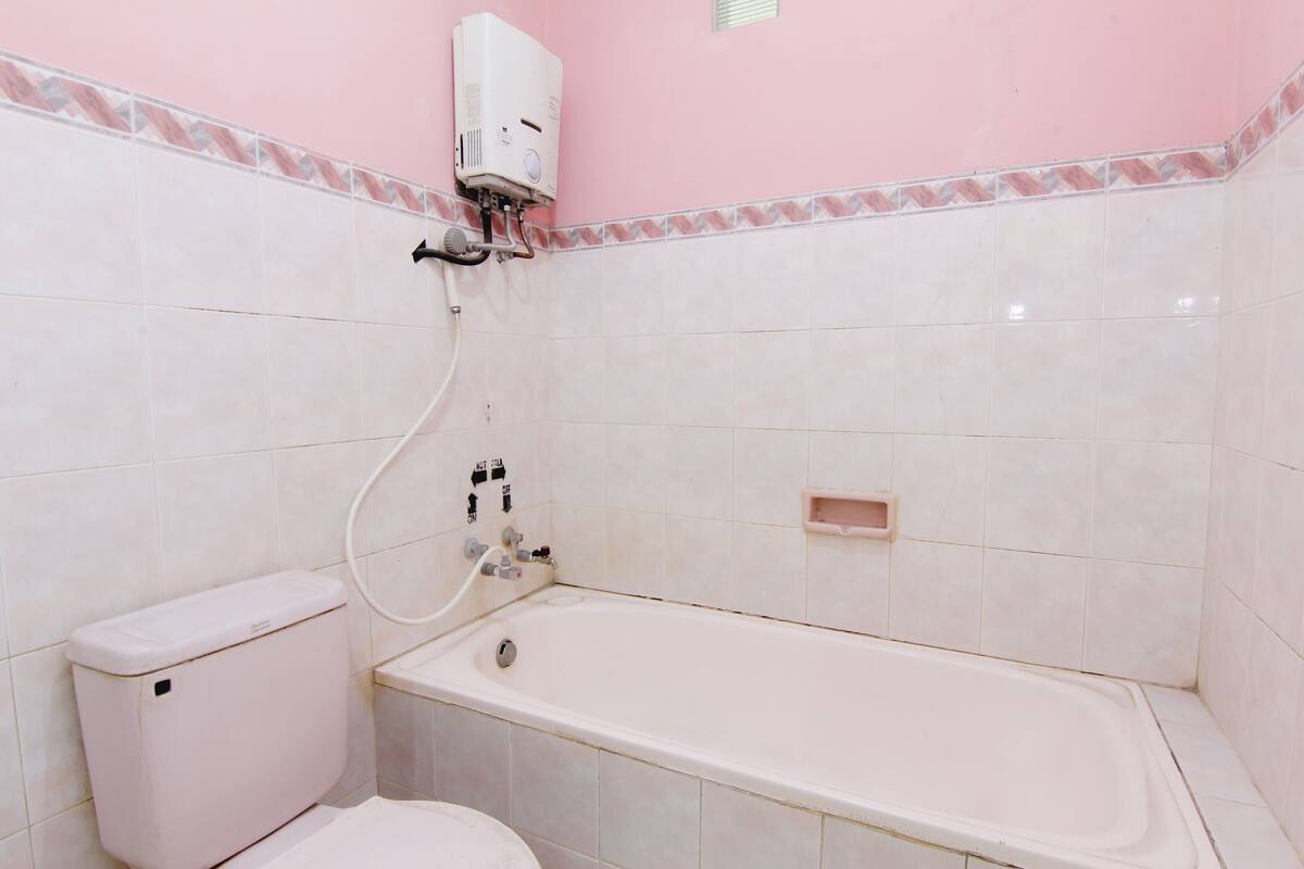 A bathroom with a toilet, a bathtub, and a water heater.