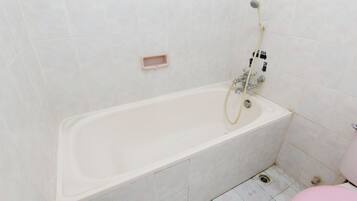 Un baño con bañera, ducha e inodoro.