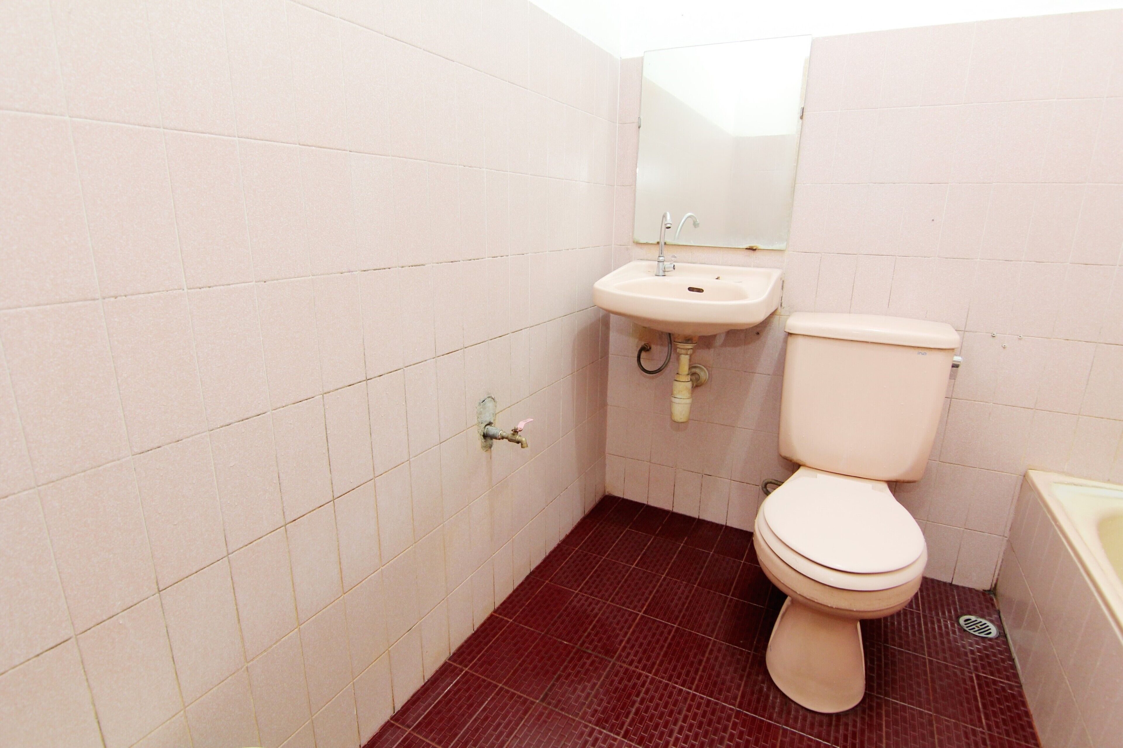 A small bathroom with a toilet, sink, and mirror.