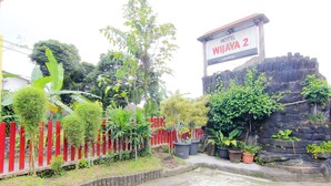Entrada de un hotel con un cartel que dice "HOTEL WIJAYA 2".