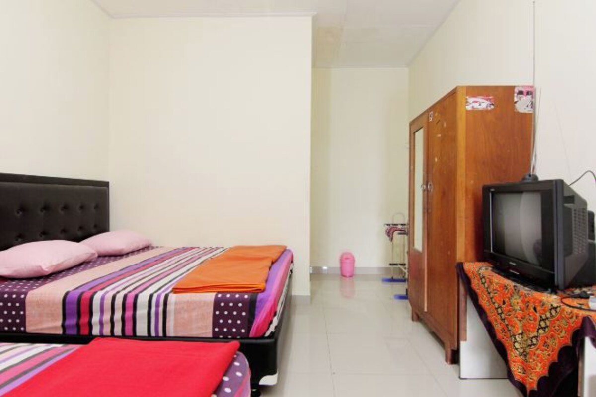 Un dormitorio con cama, televisor y armario.