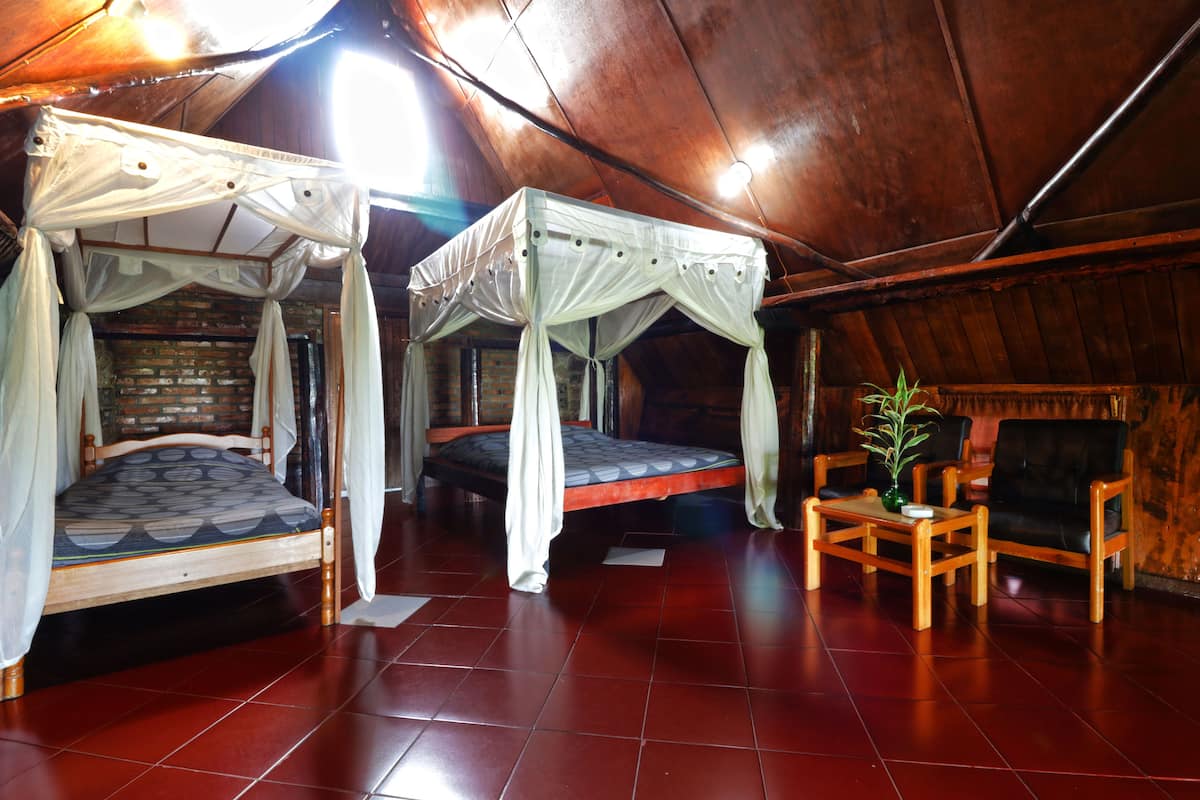A room with two beds, a small table, and a chair.