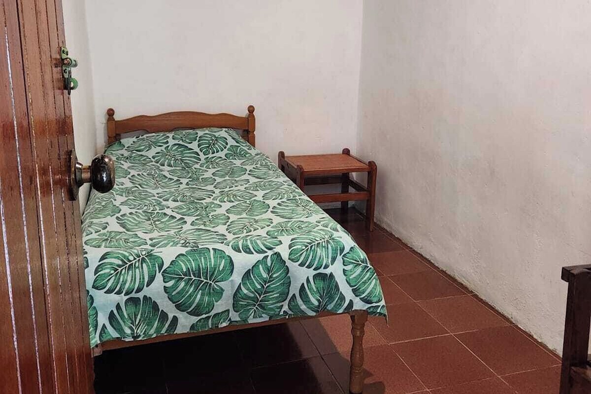 A room with a bed, a small table, and a door.