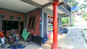 A building with a brick facade, a balcony, and a sign indicating free WiFi. - Penginapan Villa Surya Alam (Prigen)
