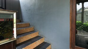 A staircase with alternating black and beige steps leading to a door. - Penginapan Villa Surya Alam (Prigen)