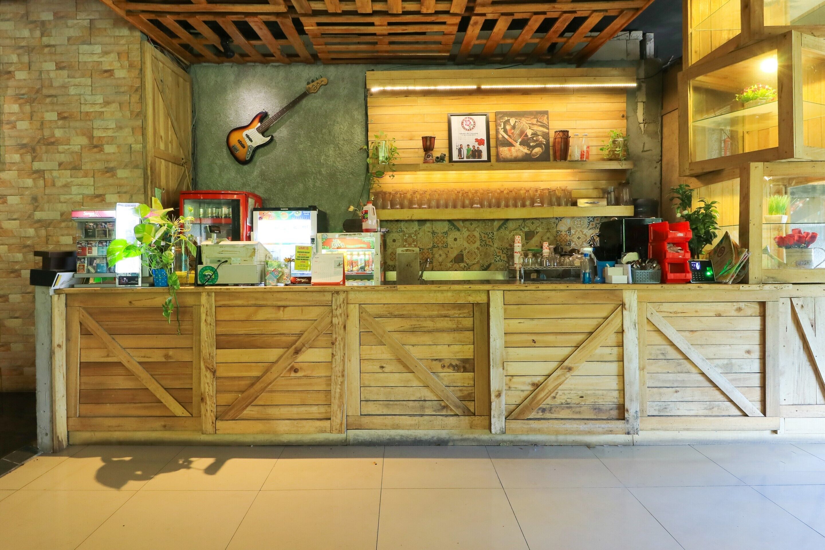 A rustic bar area with wooden counters, a guitar, and various bar items.
