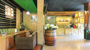 A bar area with a wooden counter, a large barrel, and a green ceiling. - Labuana Homestay and Cafe Garden Makassar (Makassar)