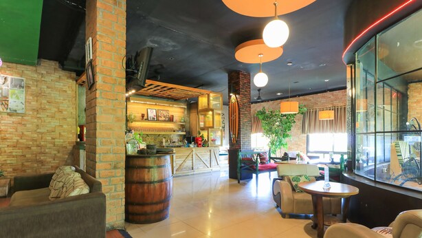 A modern interior with brick walls, leather seating, a bar area, and large windows. - Labuana Homestay and Cafe Garden Makassar (Makassar)