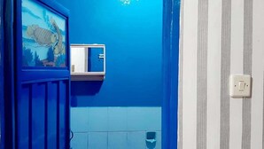 A bathroom with a blue wall, a white door, and a small window. - Dharmawati Homestay (Sidoarjo)