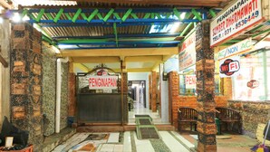 A hallway with a sign reading "PENGINAPAN" and a "free WiFi spot" sign. - Dharmawati Homestay (Sidoarjo)