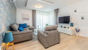 A modern living room with two sofas, a coffee table, a TV, and a small side table.