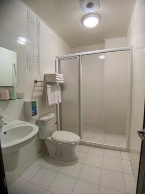 A bathroom with a toilet, sink, and shower. - Just Home (Magong)