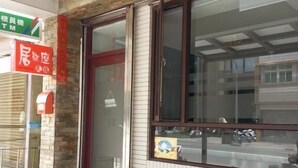 A restaurant with a stone facade, a large window, and outdoor seating with two chairs and a table. - Just Home (Magong)