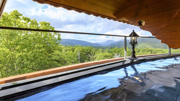 Ein Pool mit Blick auf Berge und Bäume.