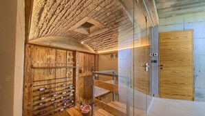 A wine cellar with wooden racks and a bench, a staircase, and a wooden door.