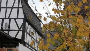 Un bâtiment traditionnel à colombages, avec une fenêtre visible et un portail en bois.