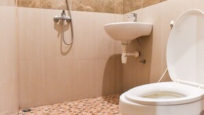 Une salle de bain avec des toilettes, un lavabo et une douche.