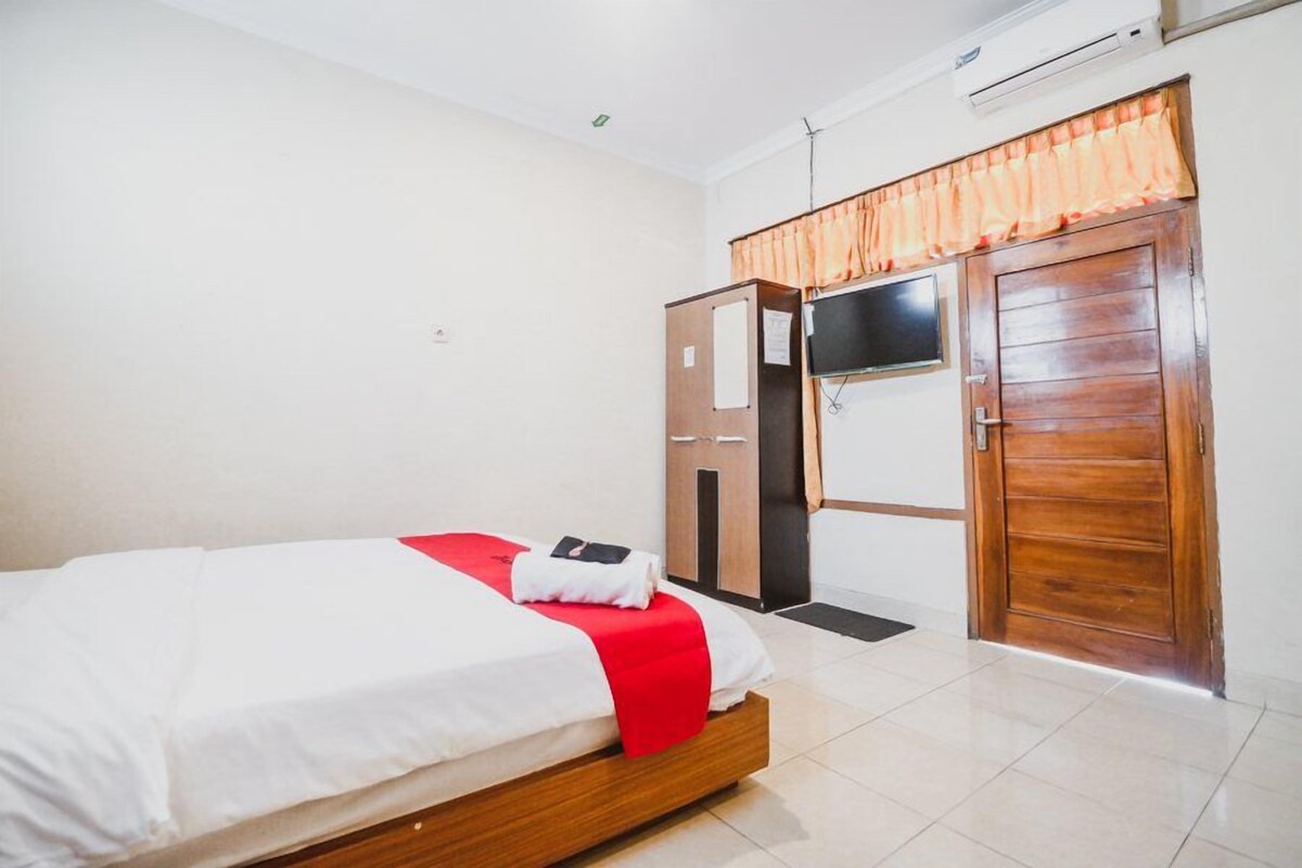 Un dormitorio con cama, armario, puerta y ventana.