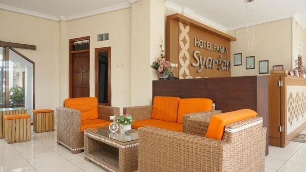 A lobby with wicker furniture, a reception desk, and a sign reading "HOTEL FAMILY Syvarchik". - RedDoorz Plus @ Jalan Parangtritis 2 (Sewon)