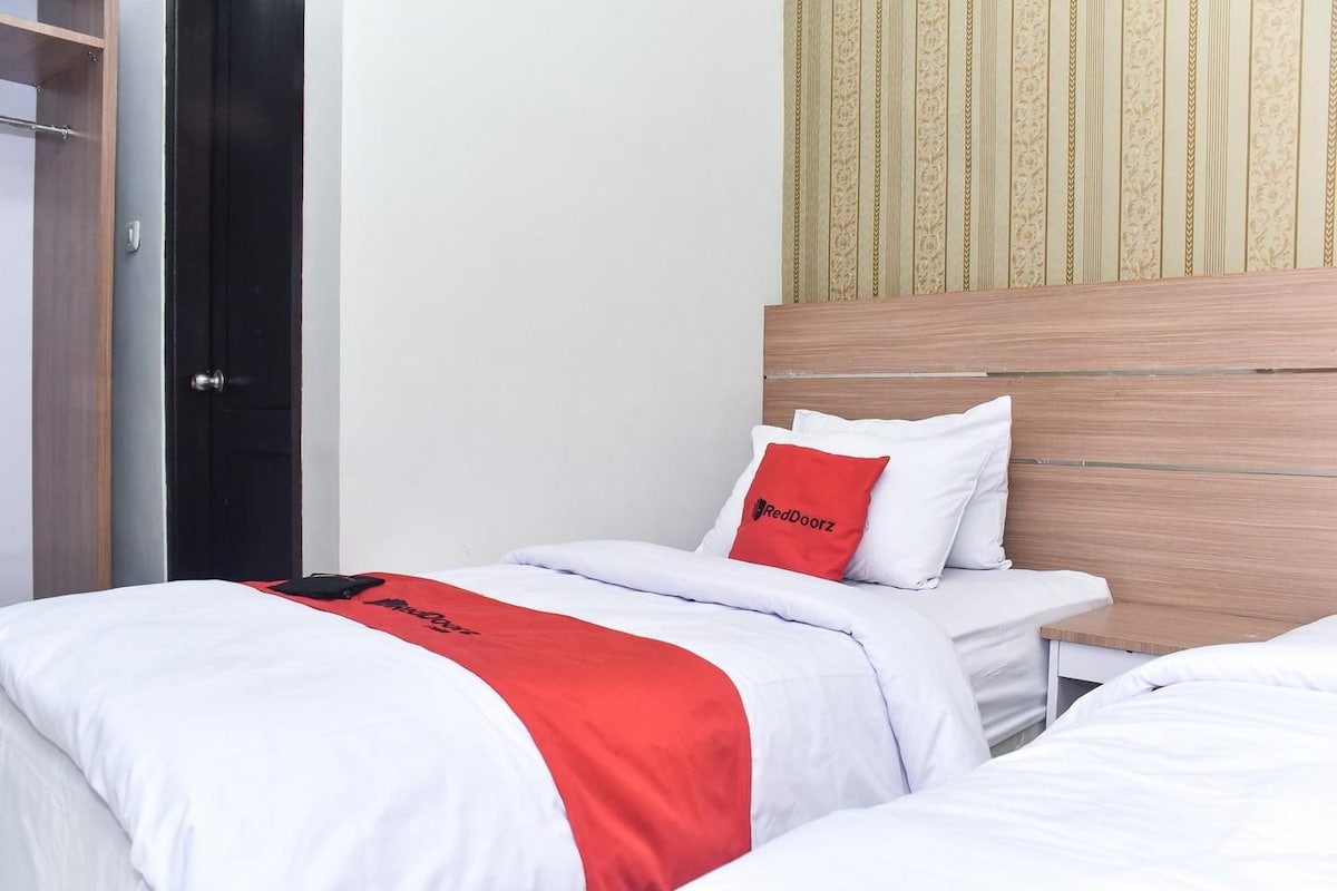 A hotel room with a bed, a nightstand, and a wardrobe.