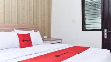 A hotel room with a bed, a nightstand, a window with blinds, and a patterned wallpaper.