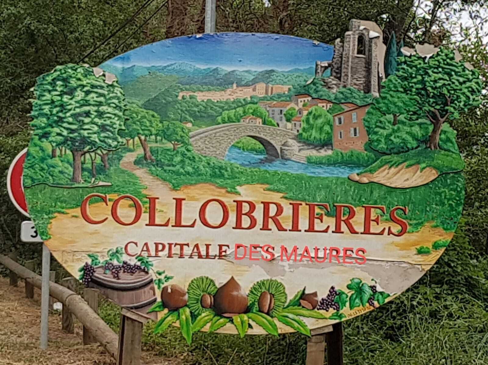 Un panneau indiquant la direction de Collobrières, représentant un paysage pittoresque avec un pont, des bâtiments et des vignobles.