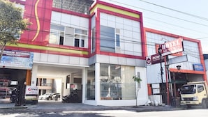 A hotel with a modern facade, large windows, and a prominent sign. - RedDoorz near Alun Alun Wonosobo (Wonosobo)
