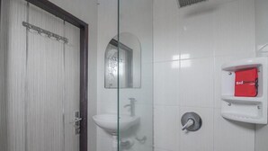 A bathroom with a glass shower enclosure, a white sink, and a red Red Door storage unit. - RedDoorz near E Walk Mall Balikpapan (Balikpapan)